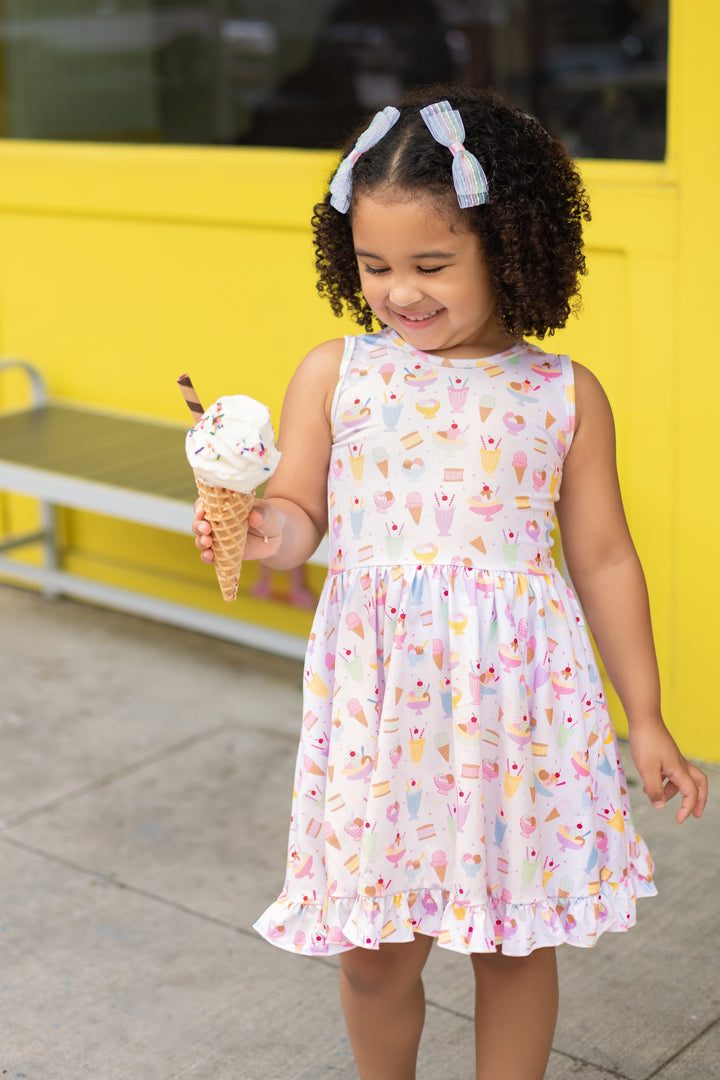 girl in white twirl dress with ice cream pastel print and matching pastel pigtail bows