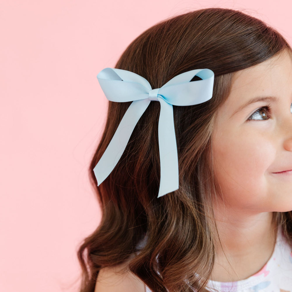 closeup of little girl wearing light blue satin ribbon bow to match summer collection