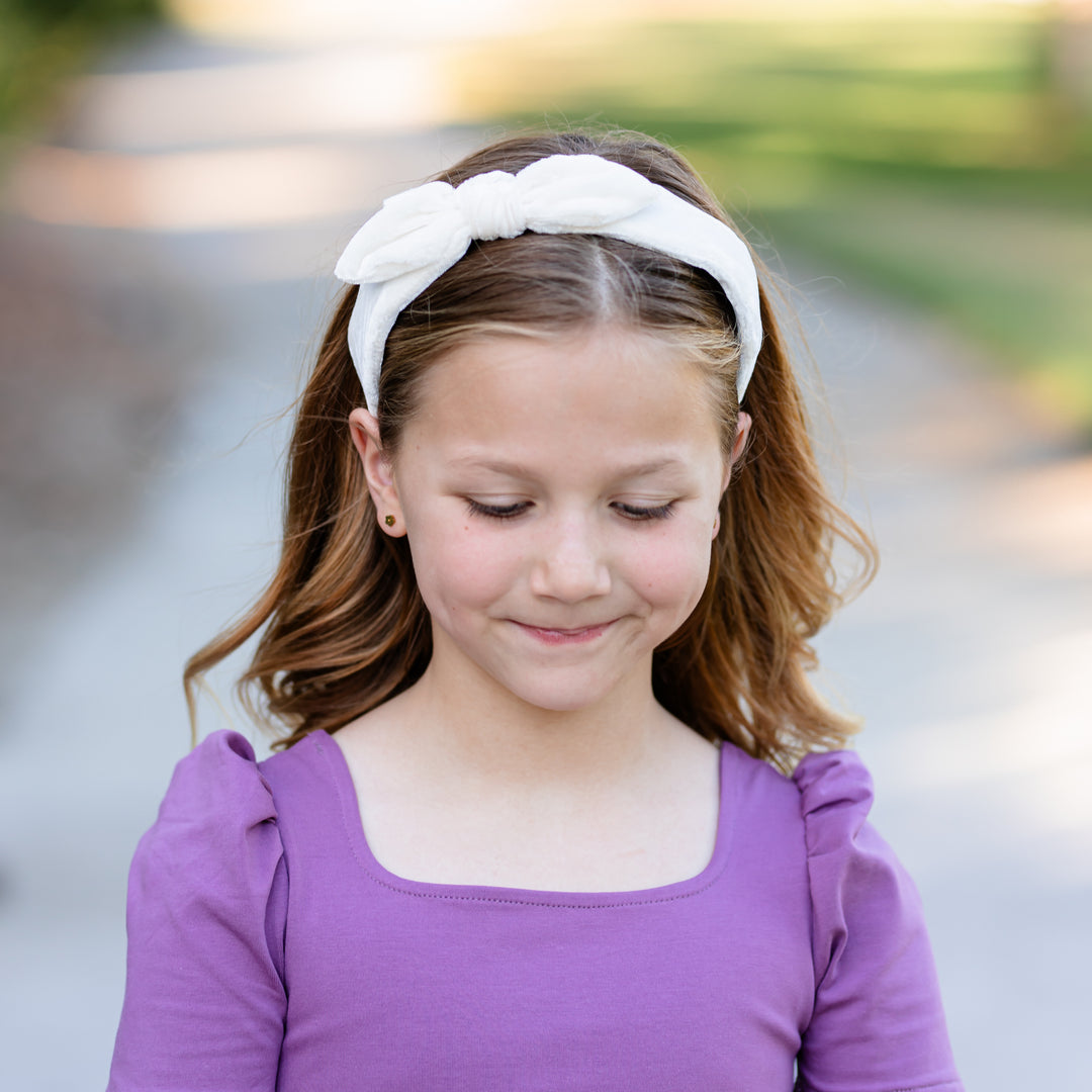 little girl in purple dress wearing ivory velvet bow headband