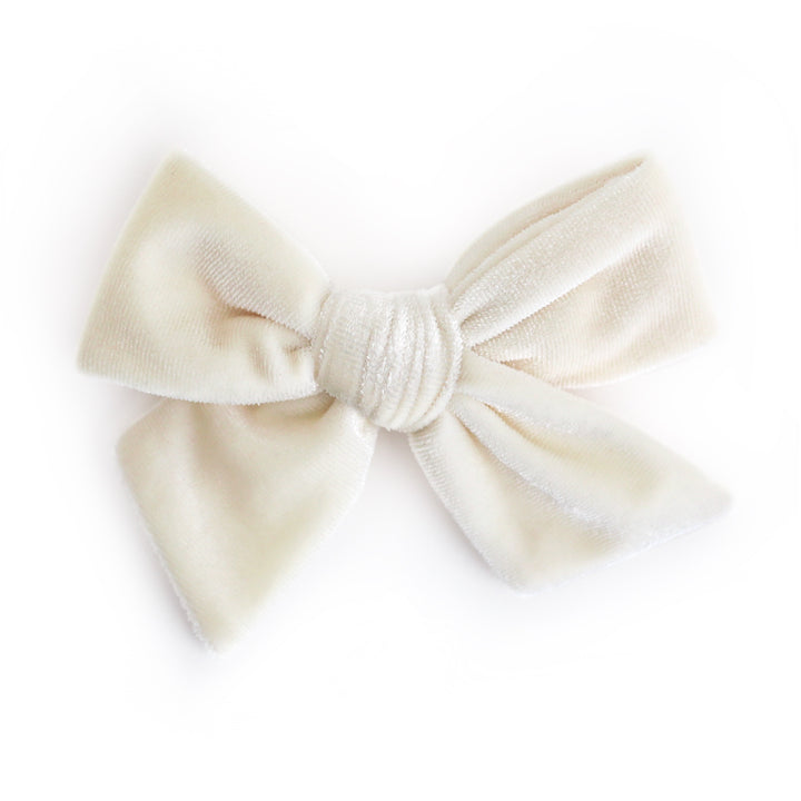 An off-white velvet hair bow with a knotted center, shown on a plain white background.
