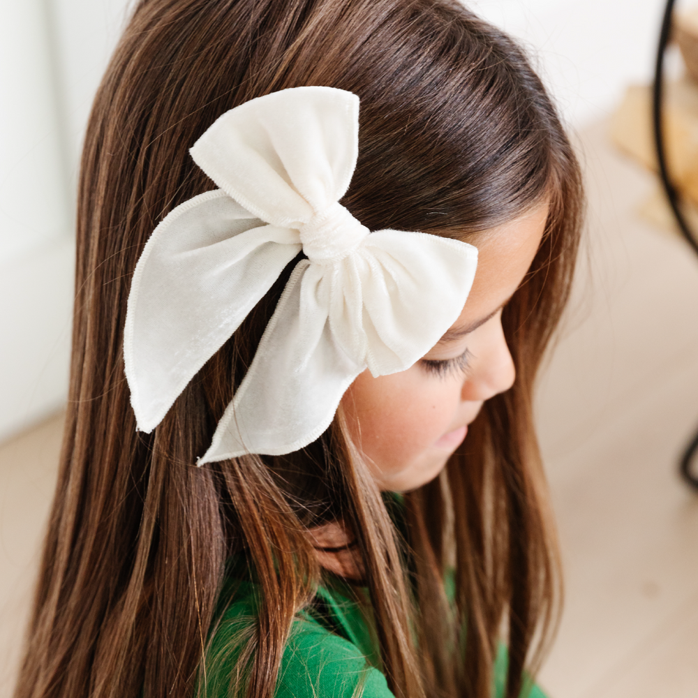 girl wearing ivory velvet party girl bow