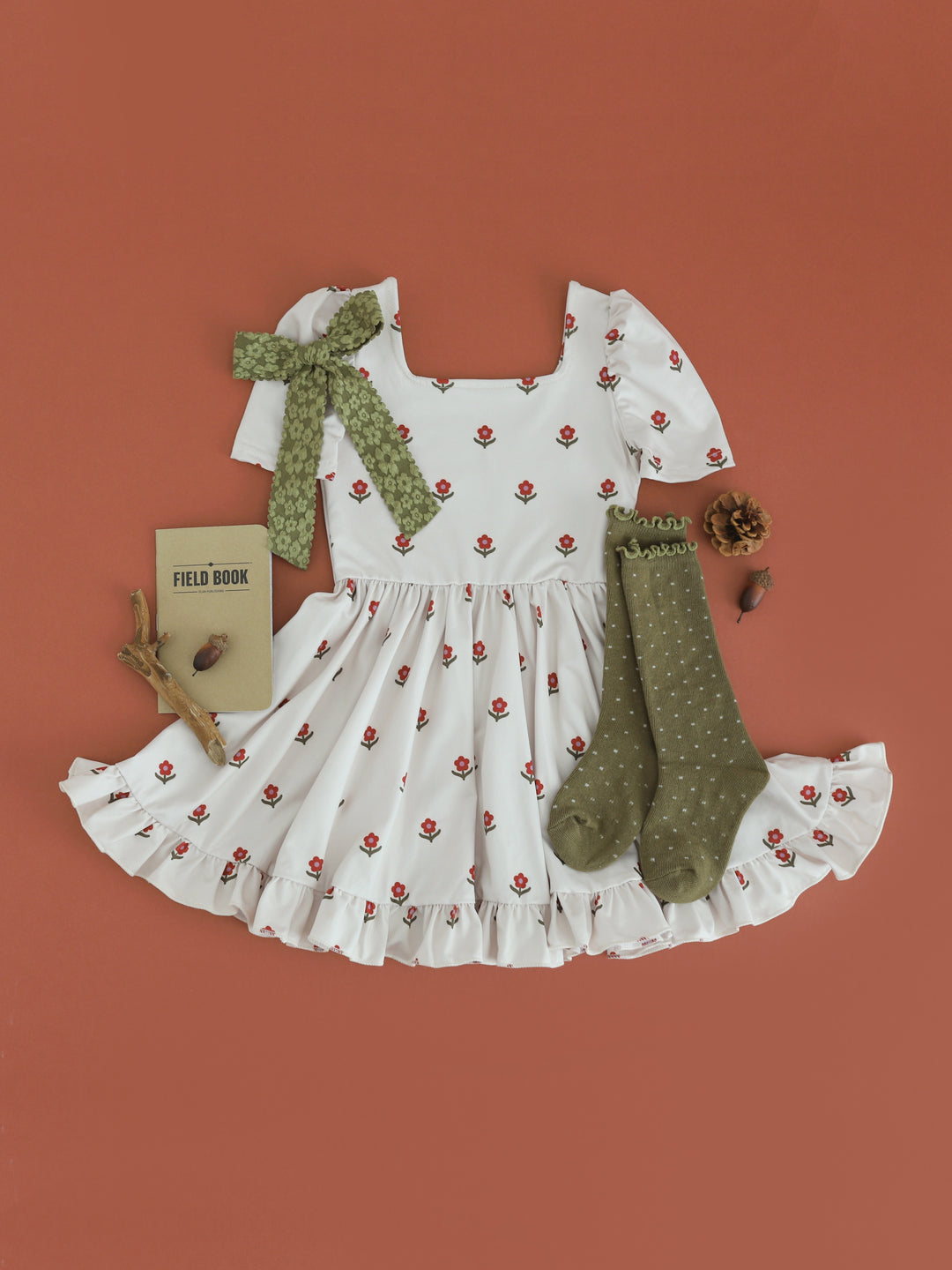 girls' light cream square neck twirl dress with rust floral print paired with olive dottie knee socks and bow