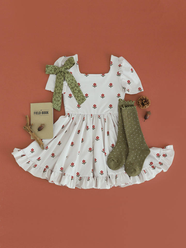 girls' light cream square neck twirl dress with rust floral print paired with olive dottie knee socks and bow
