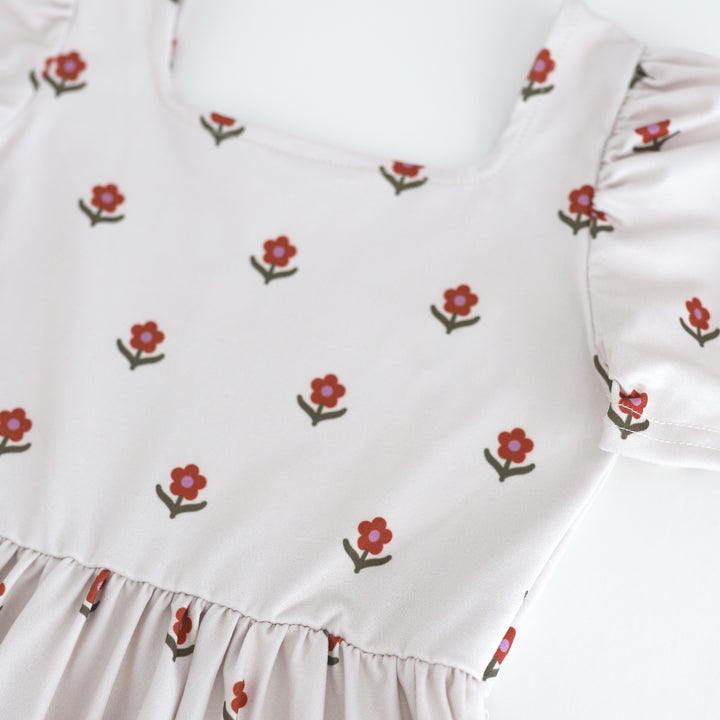 closeup of twirl dress bodice in ivory with small rust flowers with olive leaves and purple centers