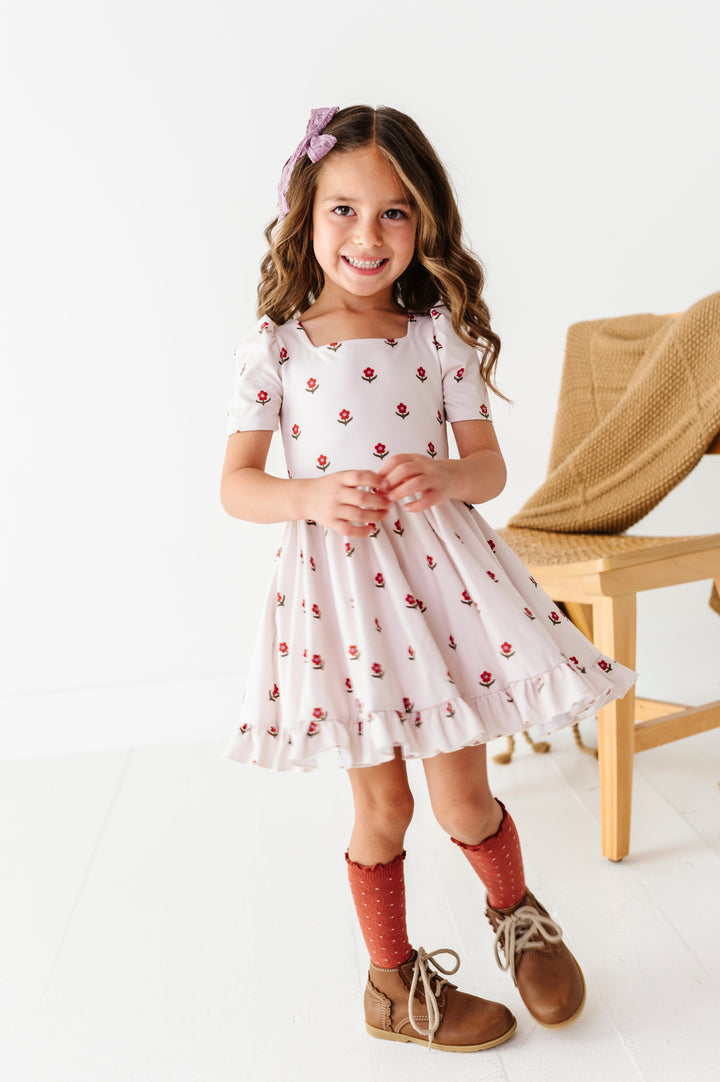 young girl twirling in ivory and rust floral twirl dress paired with rust dotted knee socks and amethyst purple lace hair bow