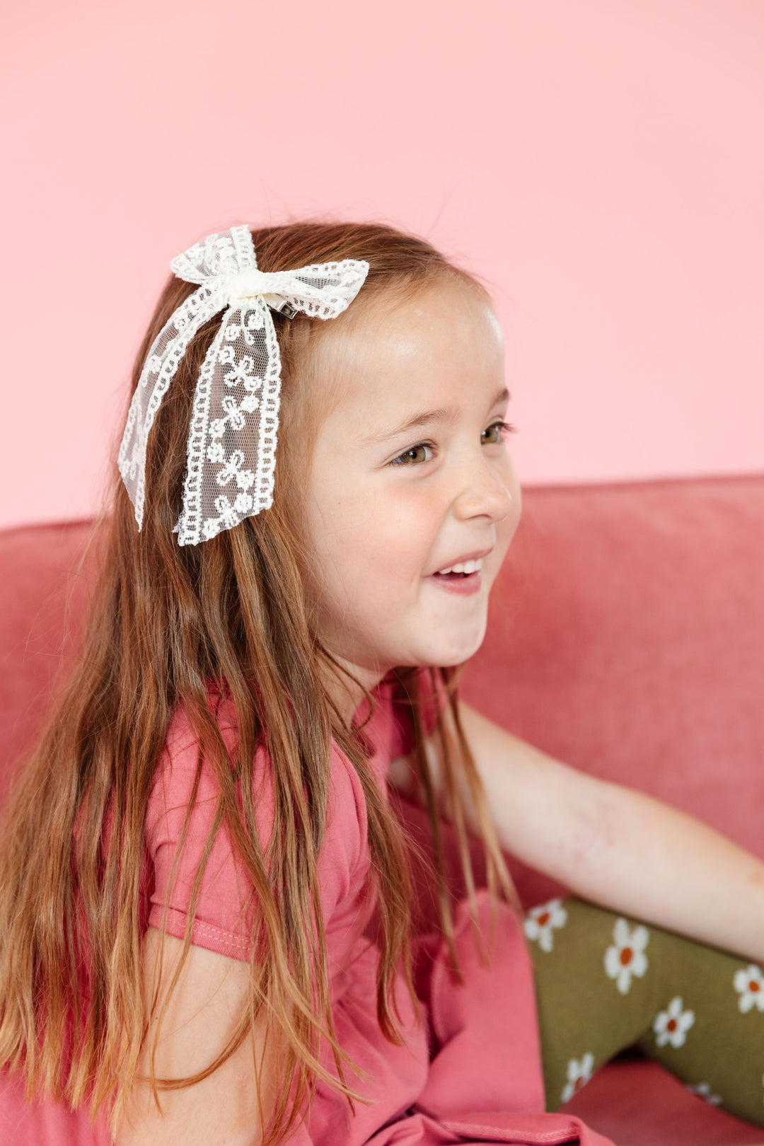 little girl in dainty lace cream bow paired with fall pink dress and green floral tights