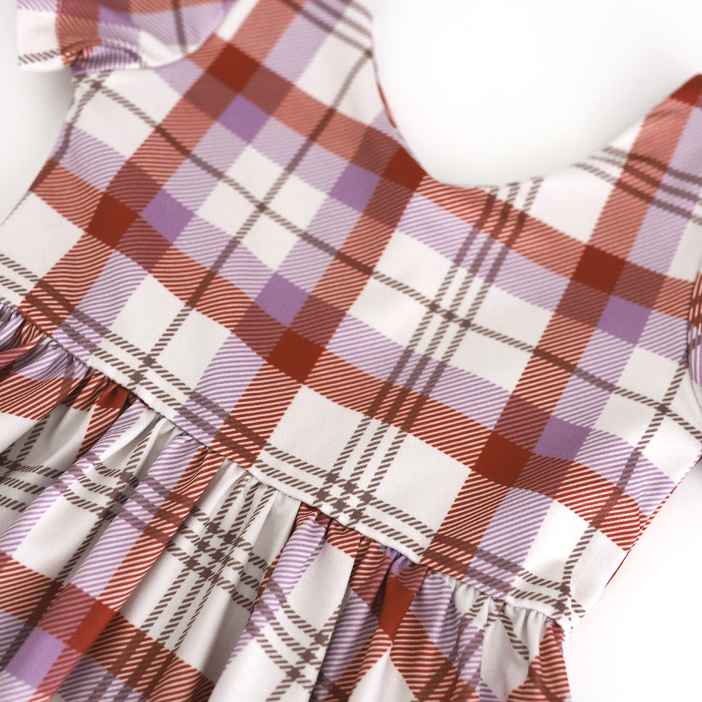 closeup of v-neck bodice with ivoyr, rust and purple plaid print for fall