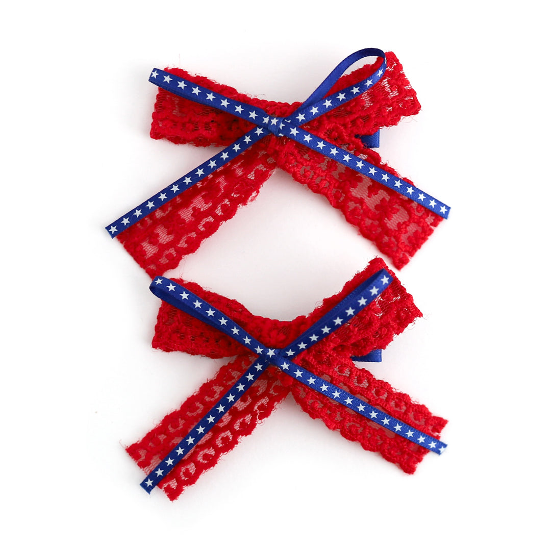 red lace ribbon pigtail bows on clips with blue star print ribbon layered on top for the 4th of July
