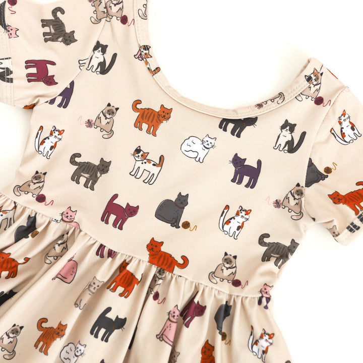 closeup of girls cat print short sleeve twirl dress with a variety of kitty cats in fall shades