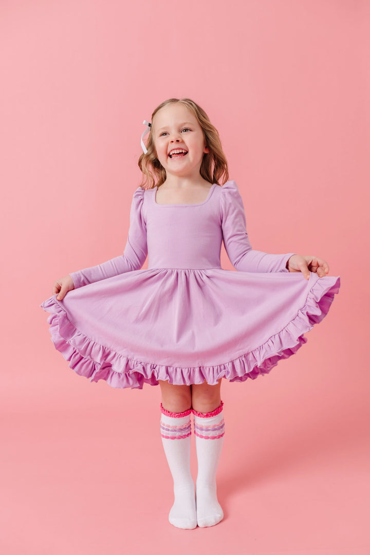 young girl in light purple long sleeve, square neck, cotton blend twirl dress pared with pastel bubble striped knee high socks for spring and valentines day