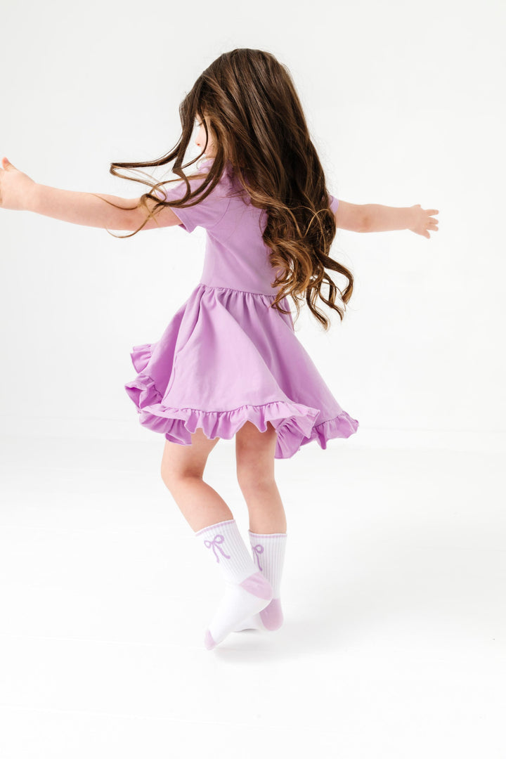 little girl twirling in lavender twirl dress with matching lavender bow crew socks