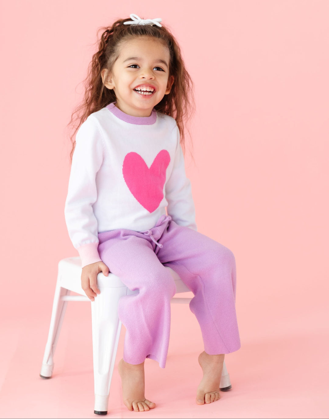 little girl sitting in pink darling heart sweater with lavender collar and matching cotton knit lavender sweater pants for Valentines