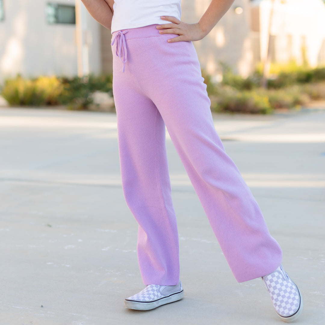 girl in pastel purple cotton knit sweater pants with drawstring waistband and lavender checkered sneakers