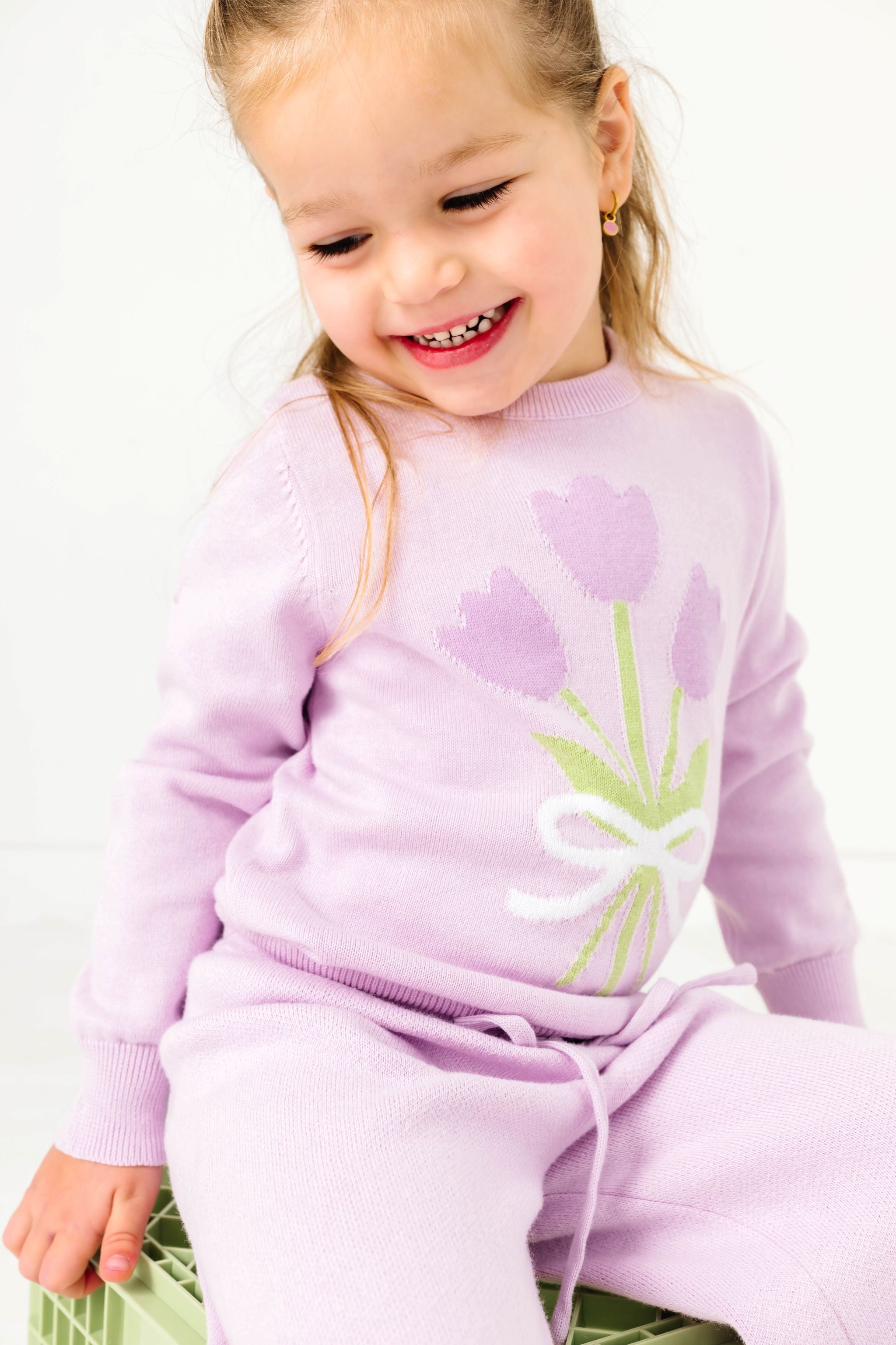little girl in lilac sweater set with lavender tulip bouquet design on top