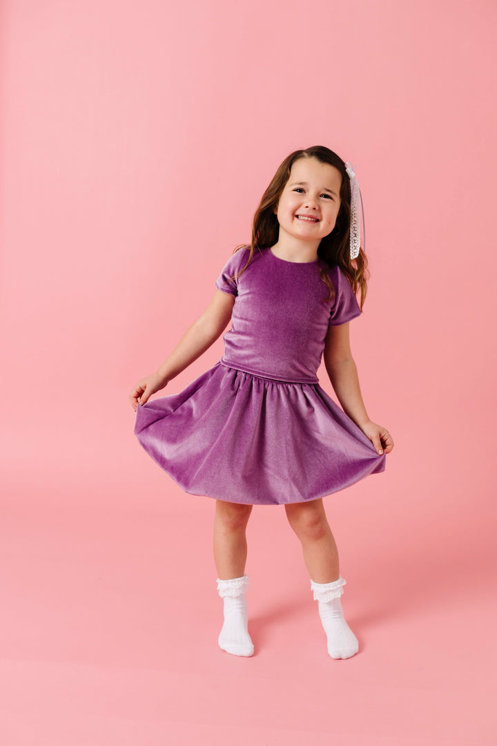 little girl in lavender velvet fitted too and matching velvet skort with white lace bobby socks for spring and valentines day