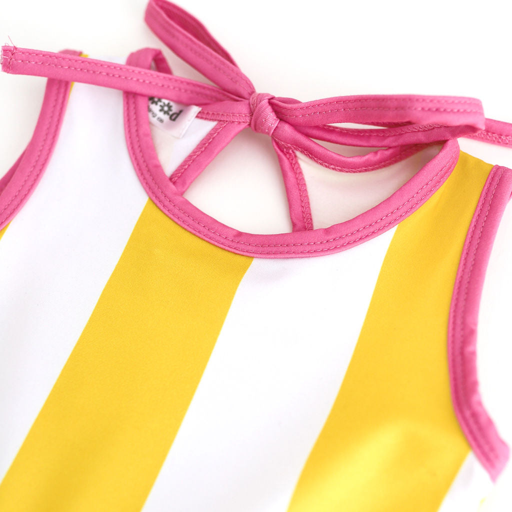 closeup of girls white and yellow wide striped sleeveless twirl with bright pink binding and keyhole tie back