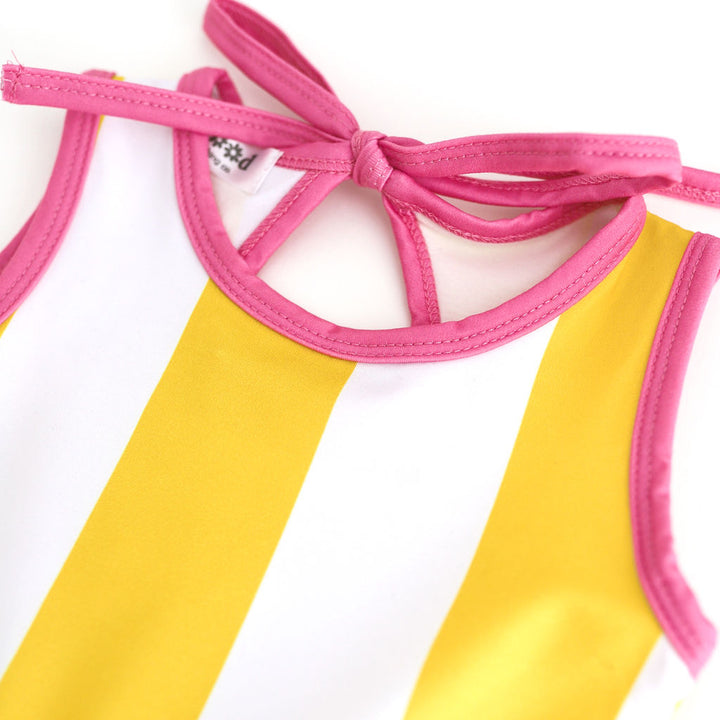 closeup of girls white and yellow wide striped sleeveless twirl with bright pink binding and keyhole tie back