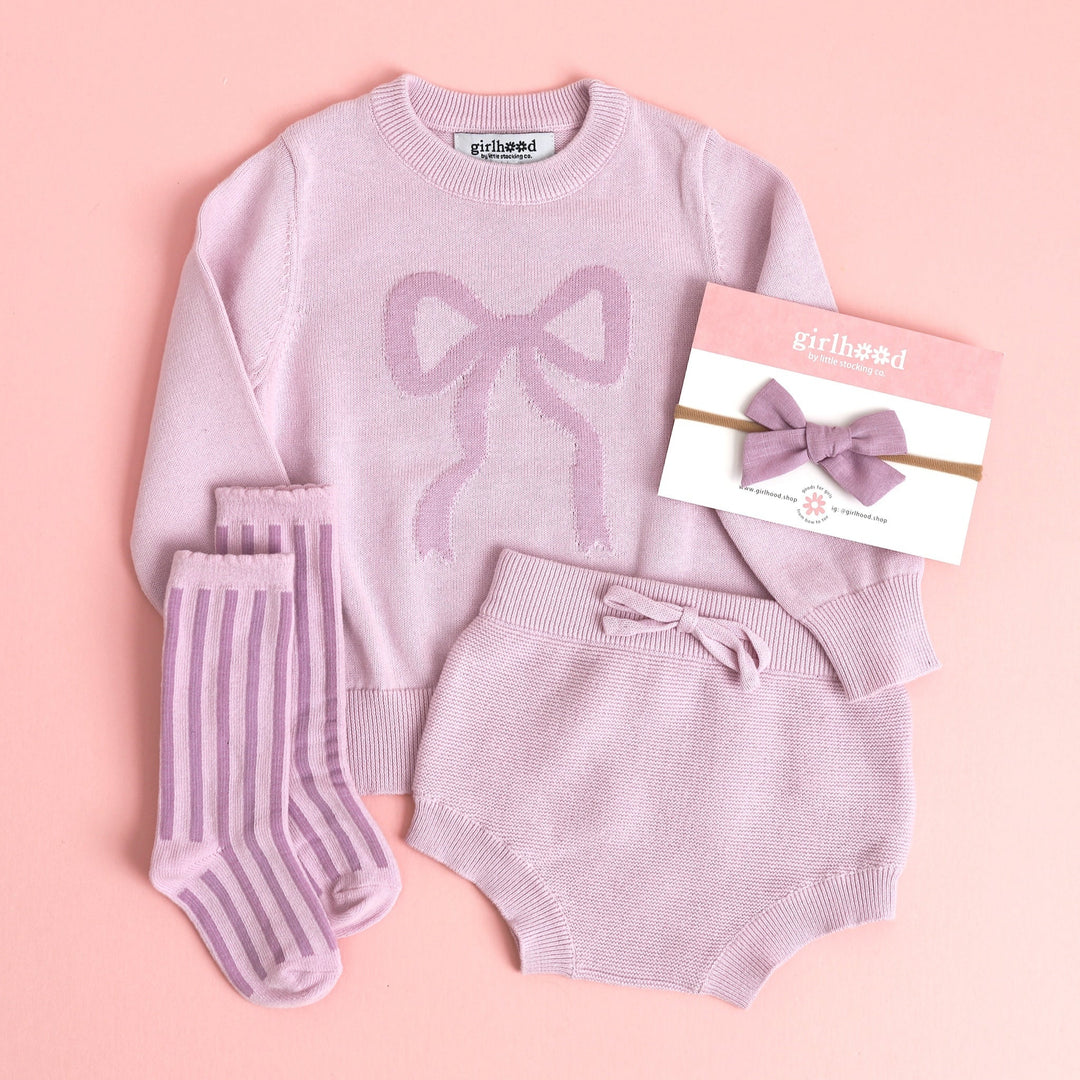 baby girl outfit of lilac cotton knit bloomers and matching sweater with bow and striped purple socks and hairbow