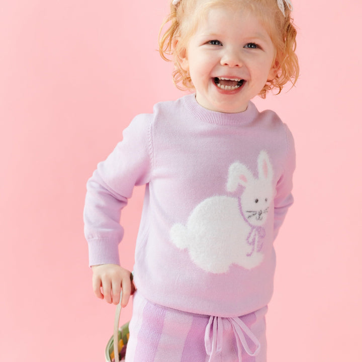 girl in lilac purple knit set with striped pants and fuzzy bunny sweater