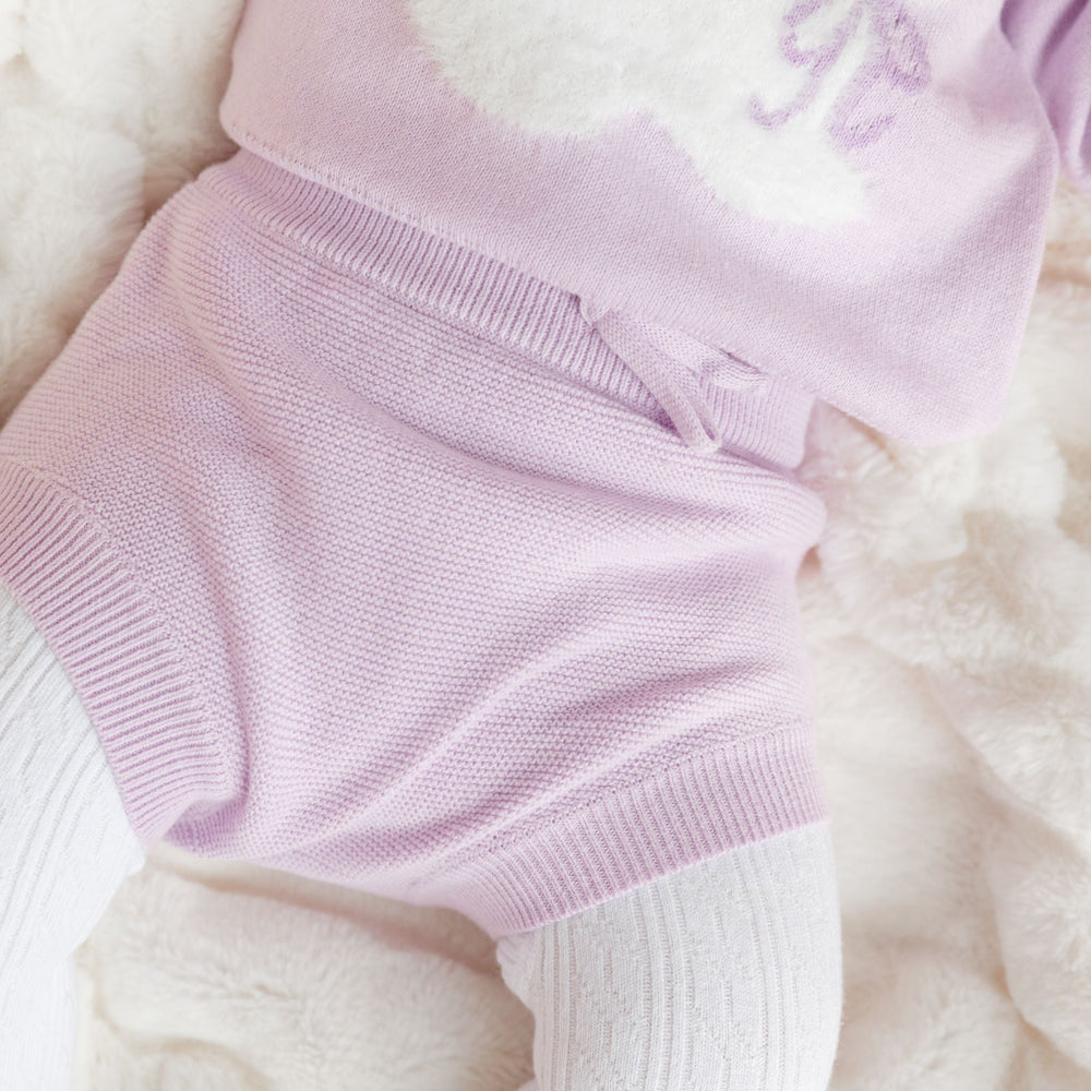 closeup of lilac cotton knit bloomers on baby girl paired with matching bunny pullover sweater and white cable knit tights for easter