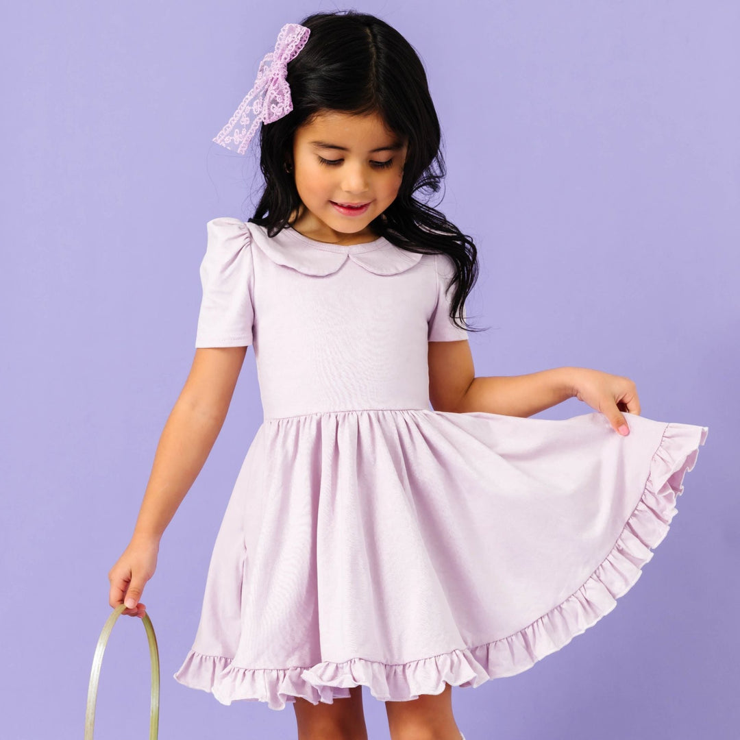 little girl holding Easter basket in pale purple cotton blend twirl dress with peter pan collar and matching lace bow