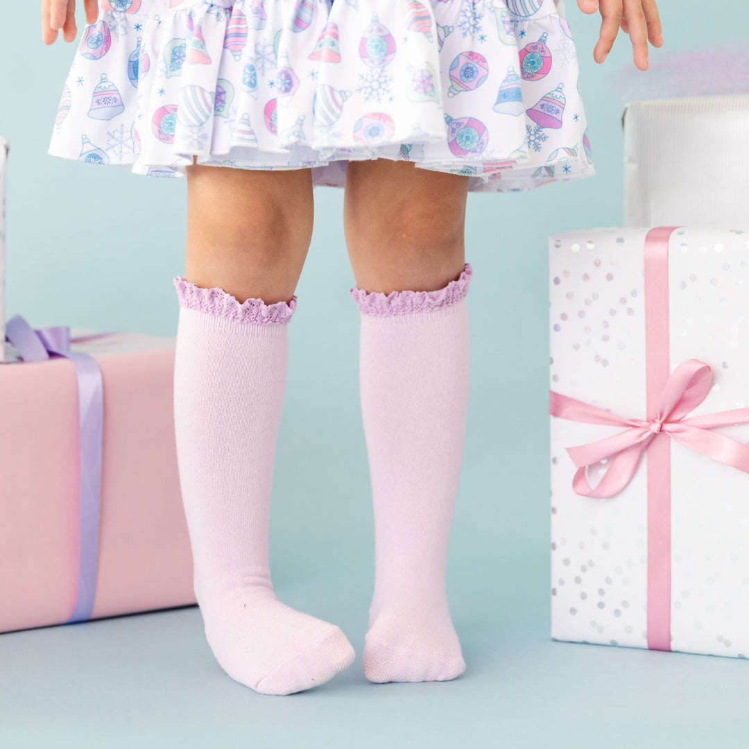 little girl in lilac knee high socks with lace trim and matching pastel holiday dress