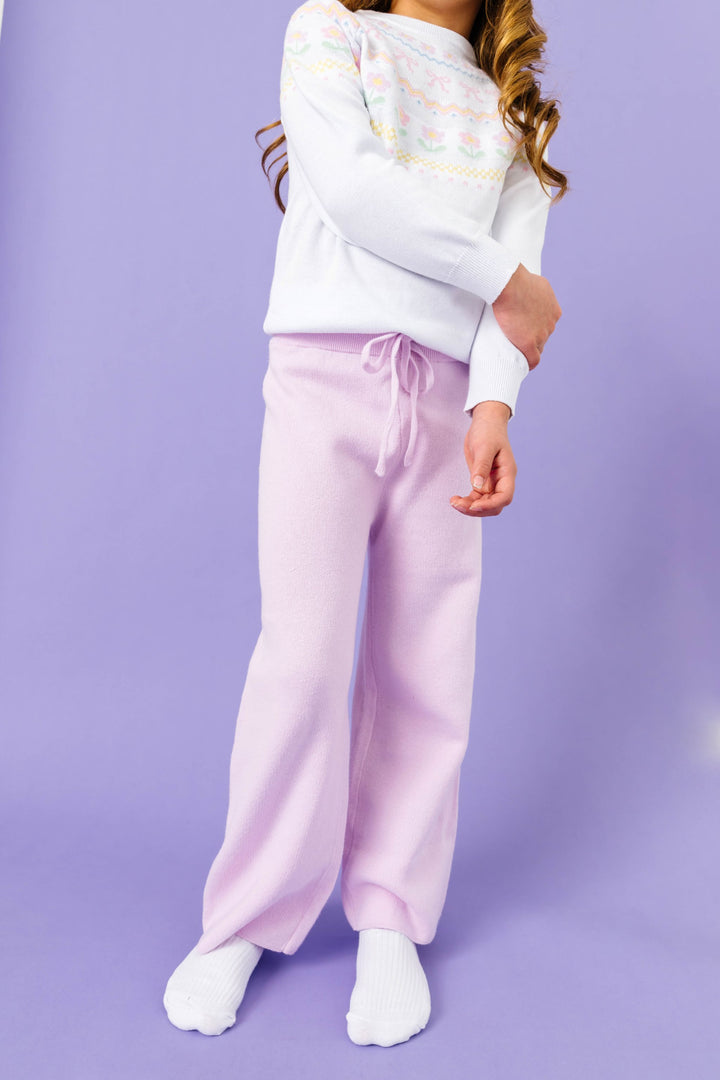 little girl in pastel purple cotton knit sweater pants with drawstring waistband and coordinating white sweater with pastel fair isle print for spring