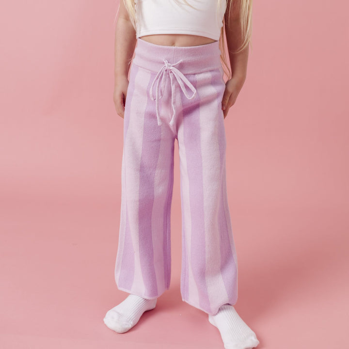 closeup of little girl in two-tone light purple sweater pants with drawstring waist and white ribbed midi socks