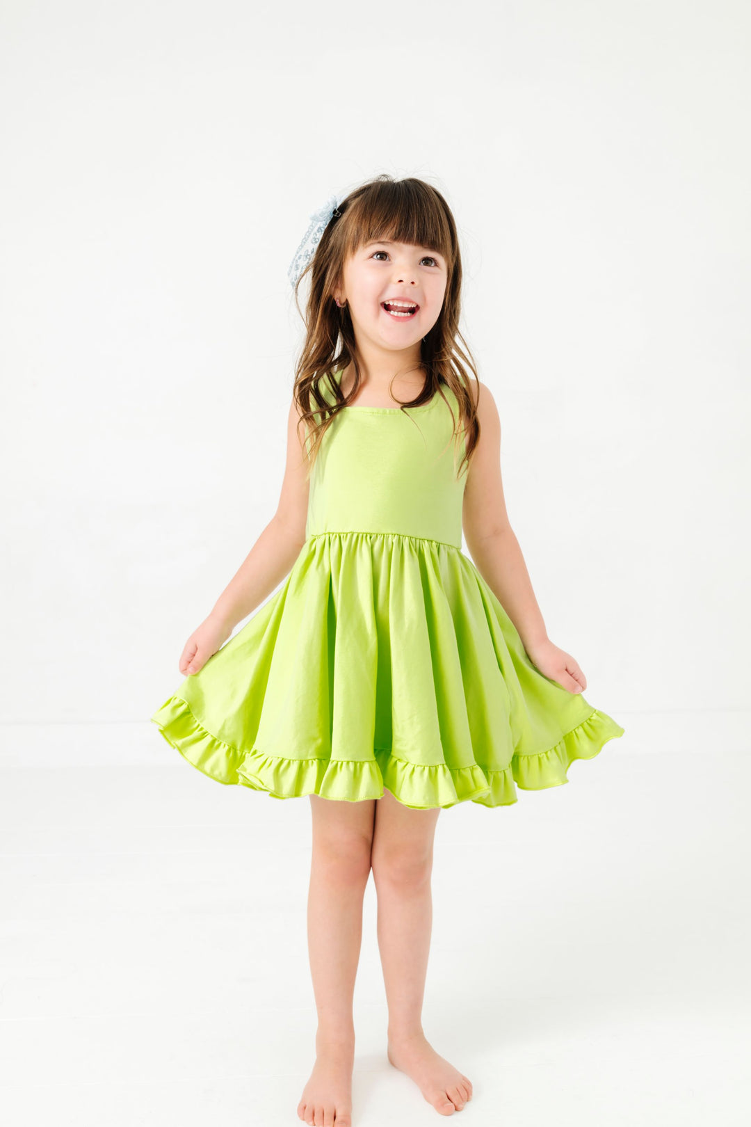 little girl in lime green sleeveless cotton blend twirl dress paired with light blue lace hair bow