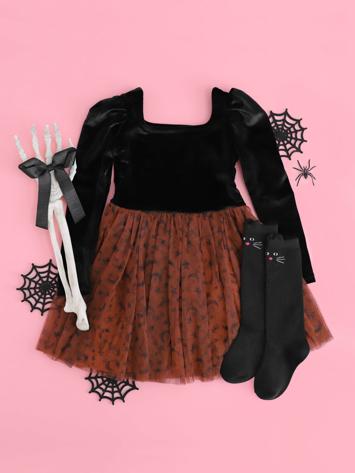 girls' Halloween square neck twirl dress with long sleeved black velvet bodice and brown tutu skirt with black moons and stars styled with black shimmery ribbon bow and black cat knee highs