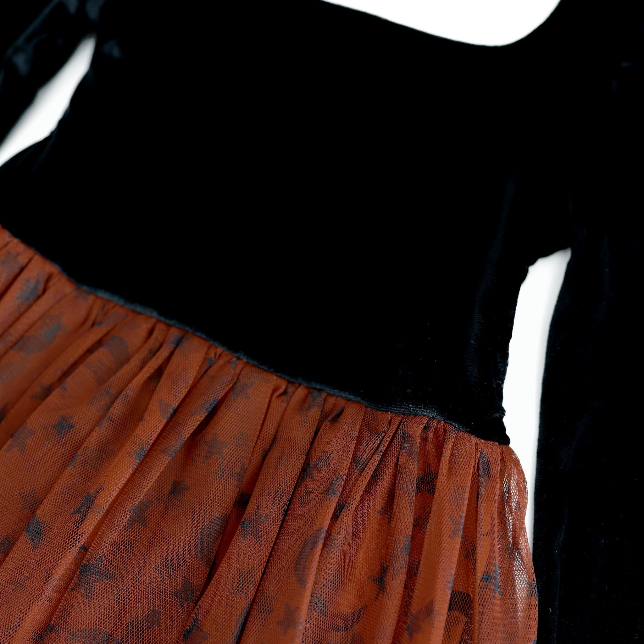 close-up of black velvet bodice and brown tutu skirt with black moon and star print on square neck Halloween dress