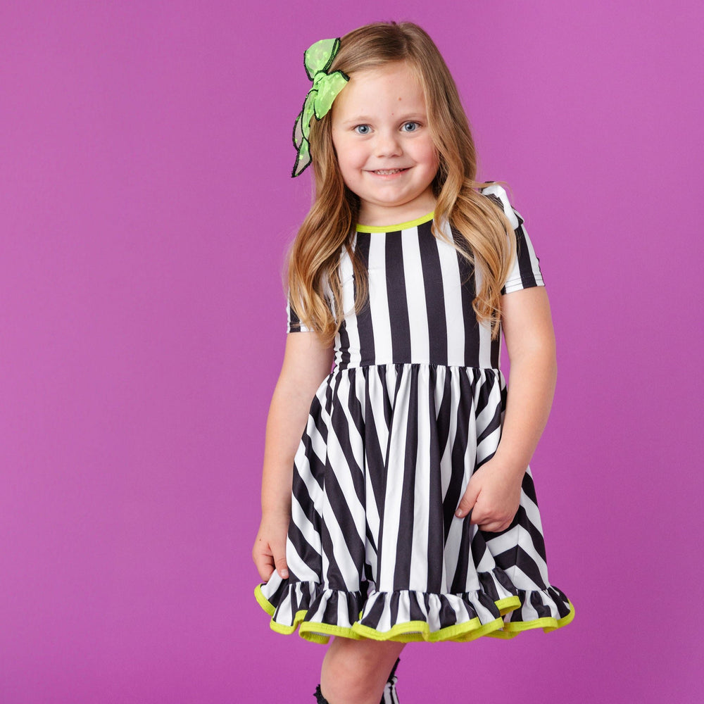 little girl wearing black and white striped halloween dress