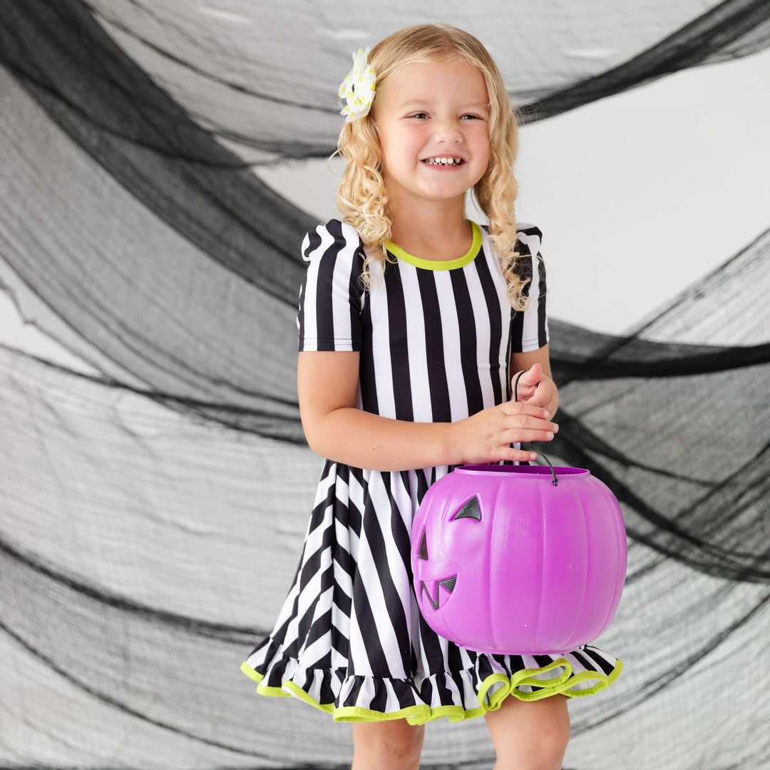 little girl wearing beetlejuice inspired dress for halloween