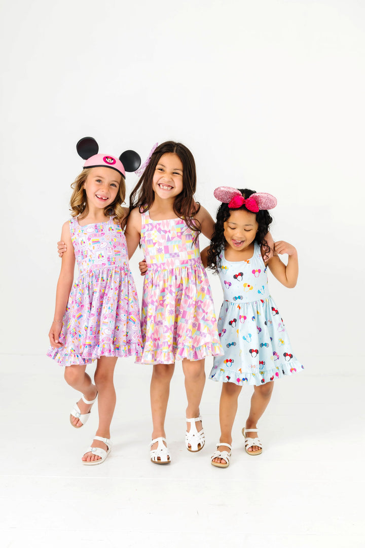 three girls in disney inspired sleeveless print twirl dresses and mouse ears for a day at the parks