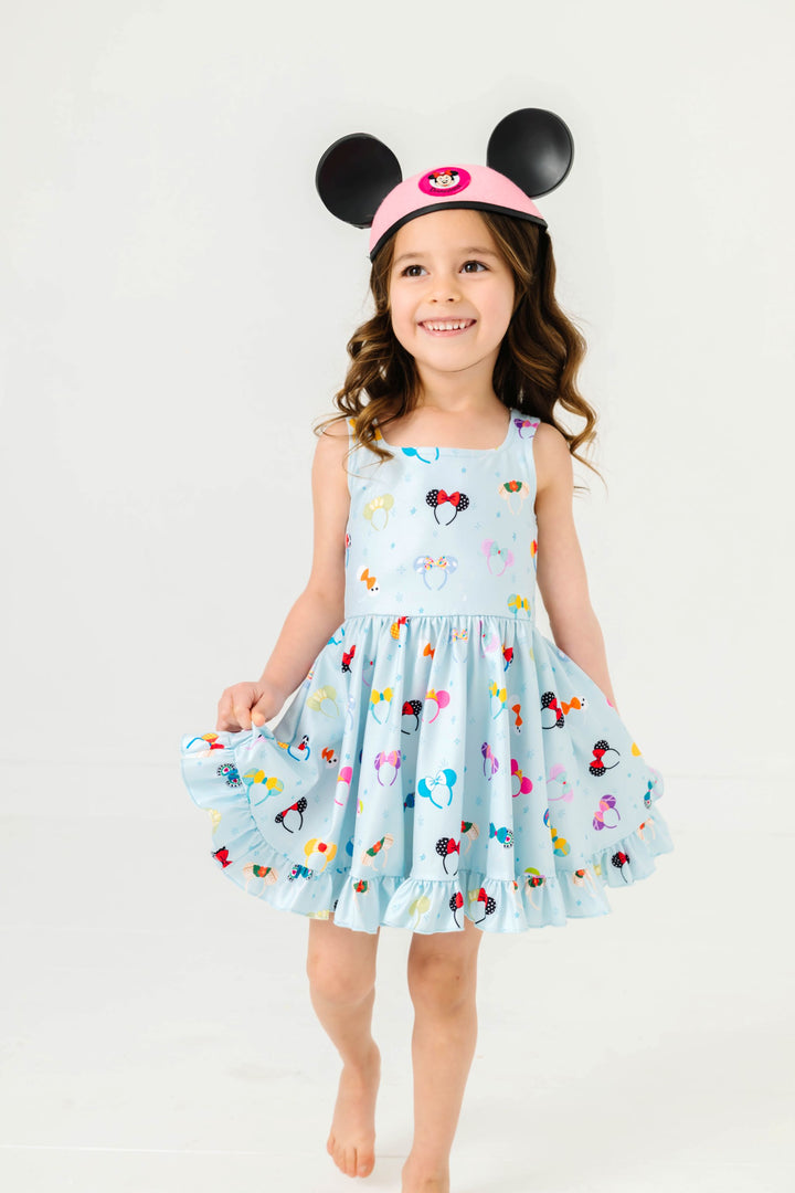 little girl in blue sleeveless twirl dress with magical ear print and minnie mouse vintage hat