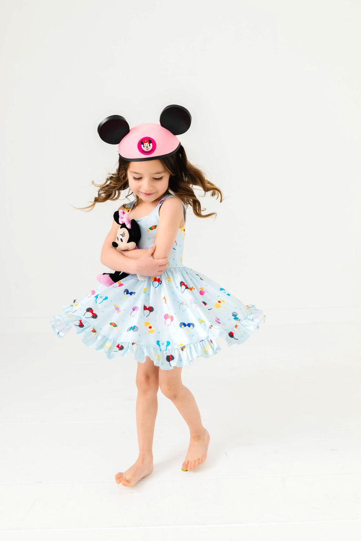little girl twirling with minnie mouse toy in blue magical ears sleeveless twirl dress