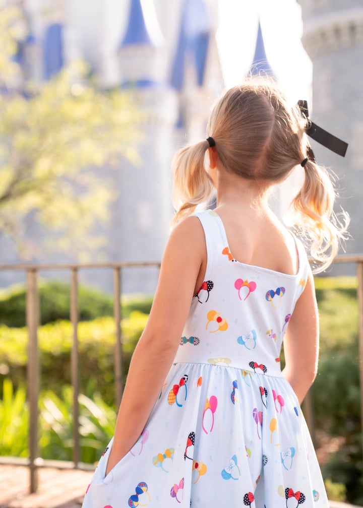 little girl in front of castle in blue magical ears sleeveless twirl dress