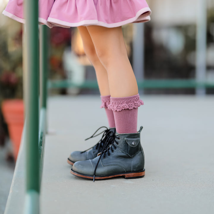 little girl wearing mauve lace ruffle socks with black fall boots