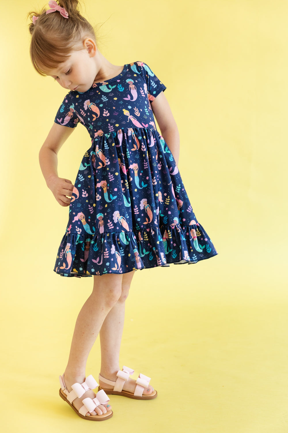 mermaid print dress on girl wearing matching pink hair bows and sandals