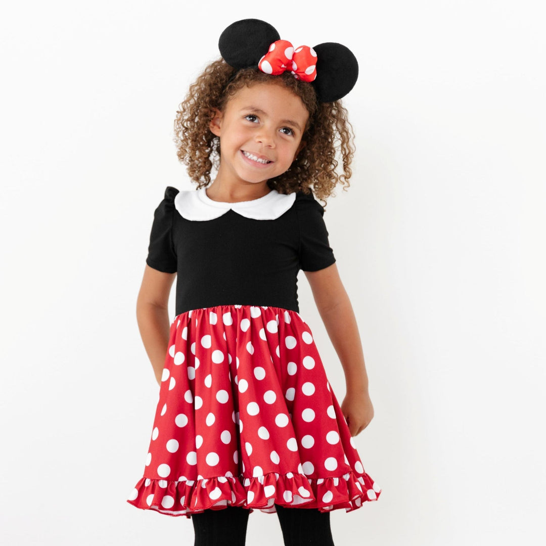 little girl in Minnie Mouse inspired twirl dress with white peter pan collar, black bodice and red with white polka dot skirt 