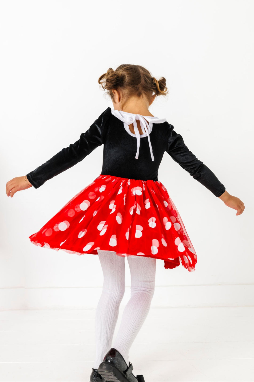 little girl twirling in Minni inspired velvet tutu dress to show tie back design