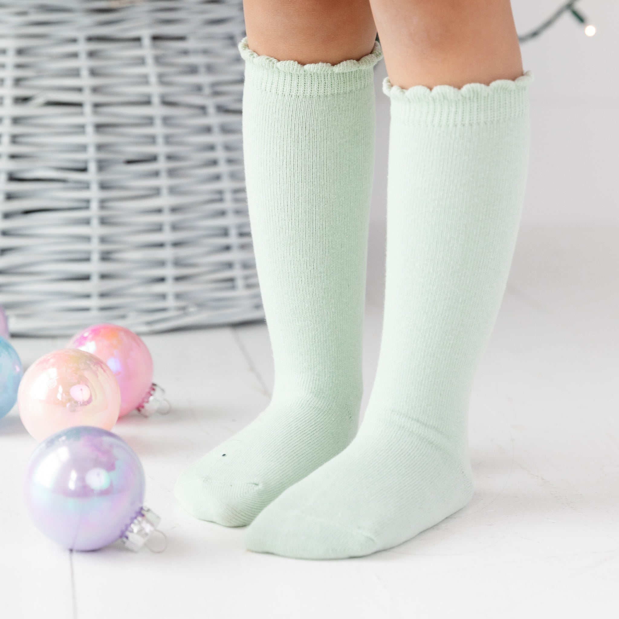 girl wearing scalloped knee high socks in pastel green