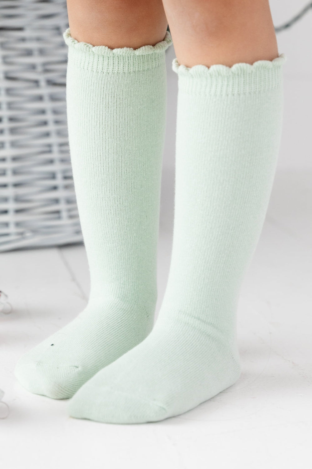 girl wearing scalloped knee high socks in pastel green