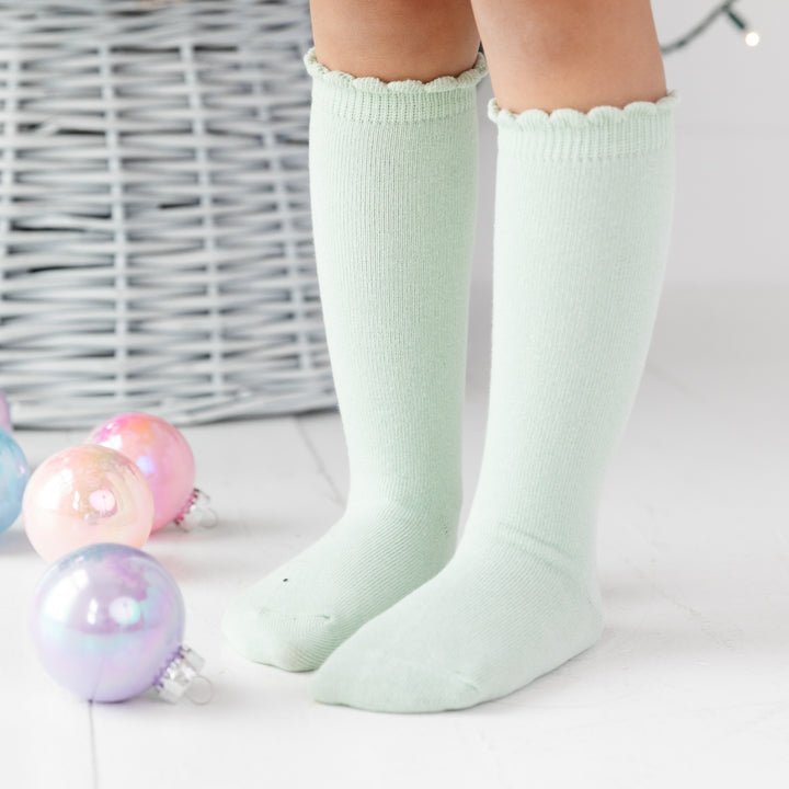 girl wearing scalloped knee high socks in pastel green