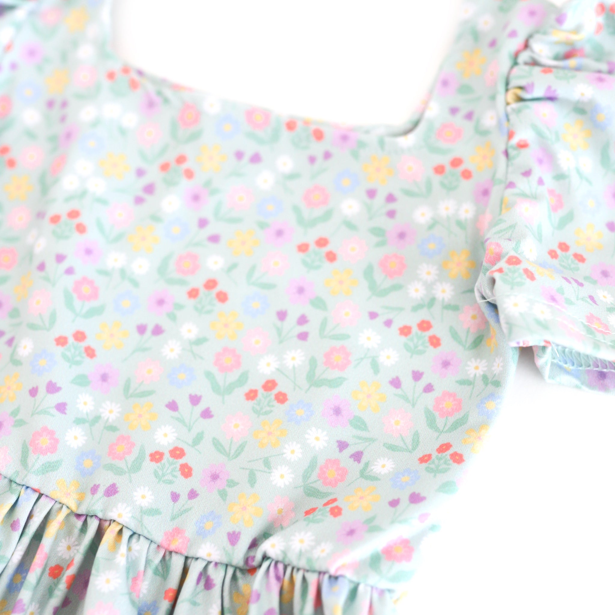 closeup of spring floral twirl dress print with soft mint background and pastel flowers