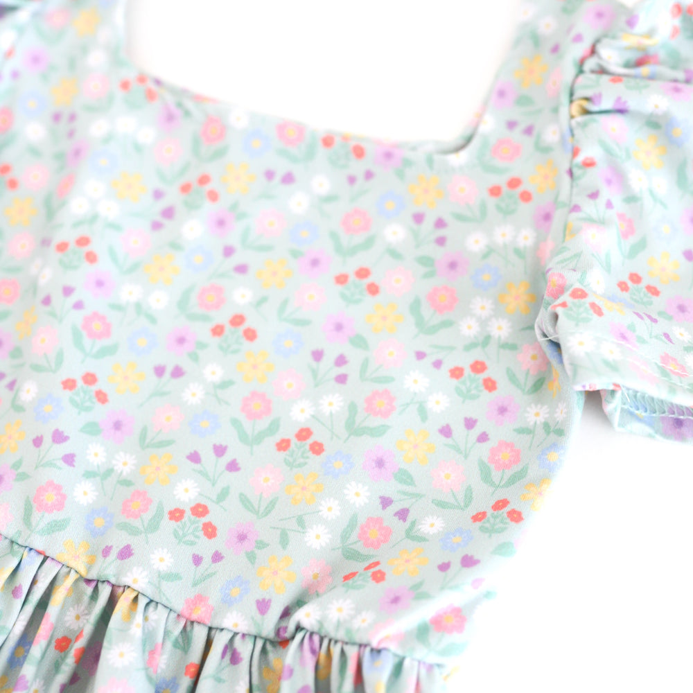 closeup of spring floral twirl dress print with soft mint background and pastel flowers