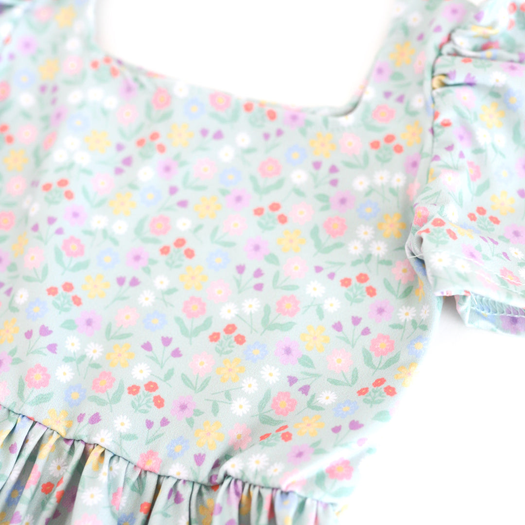 closeup of spring floral twirl dress print with soft mint background and pastel flowers