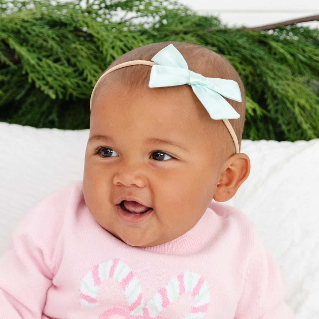 baby girl in pastel mint satin bow on soft nylon headband with matching pink candy cane sweater set