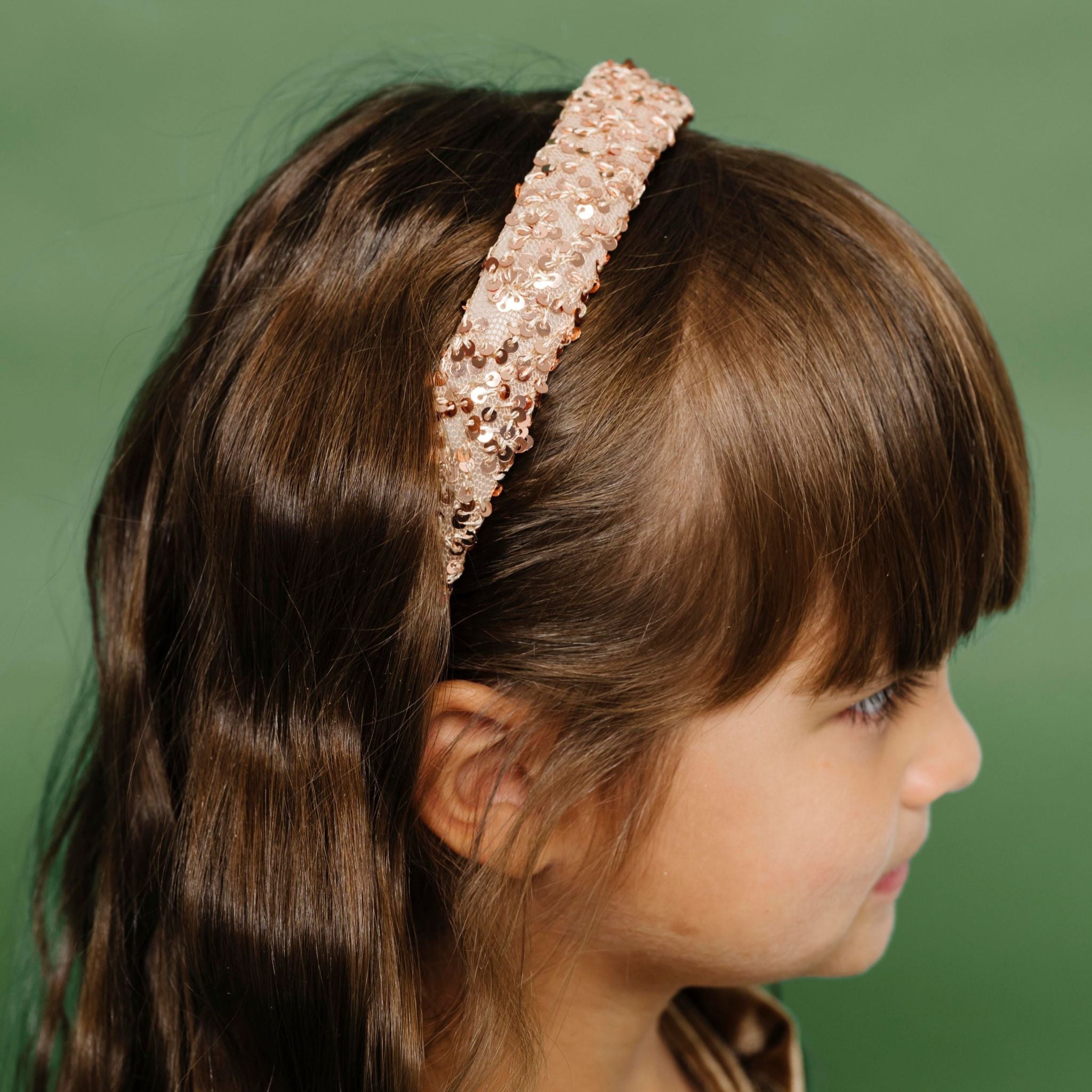 little girl in light brown sequin headband paired with matching velvet tutu dress