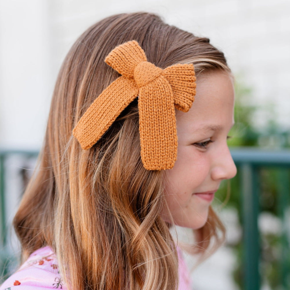 little girl in mustard knit bow on clip and pink velvet floral top for fall